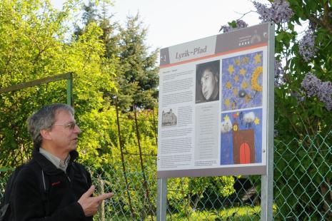 Hans-Werner Johann vor den Bildern zu "Der Sternenanzünder" von Mascha Kalecko
